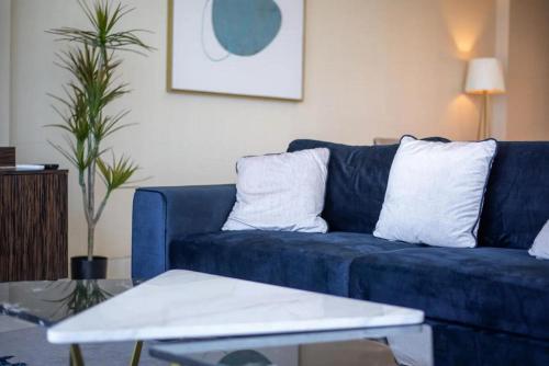 a blue couch in a living room with a table at GLOBALSTAY Palm View in Dubai
