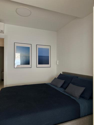 une chambre avec un lit avec deux tableaux au mur dans l'établissement Maison Azurea, à Roquebrune-Cap-Martin