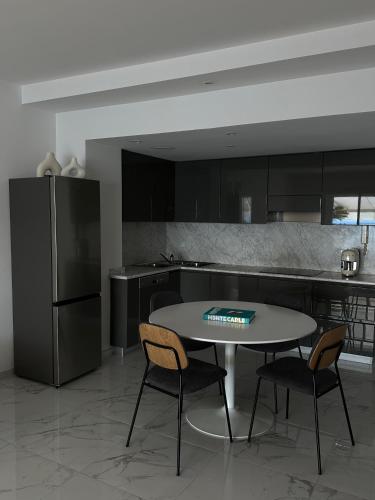 La cuisine est équipée d'une table, de deux chaises et d'un réfrigérateur. dans l'établissement Maison Azurea, à Roquebrune-Cap-Martin