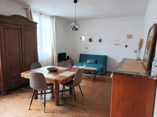 un salon avec une table et un canapé bleu dans l'établissement Charmant T2 place de Verdun, à La Rochelle
