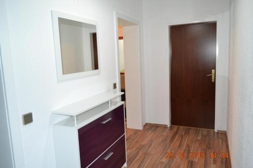 a bathroom with a sink and a mirror and a door at Pension Hexagon in Spittal an der Drau