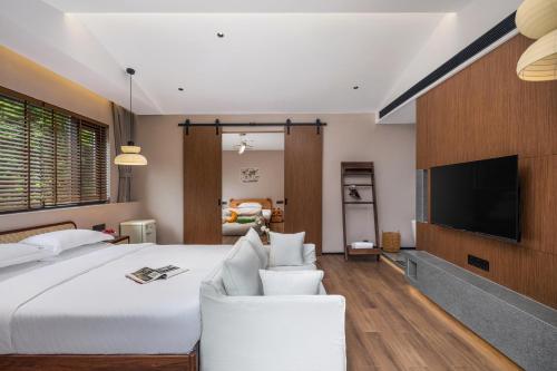 a bedroom with a large bed and a flat screen tv at Dyed Mount Boutique Hotel in Yangshuo