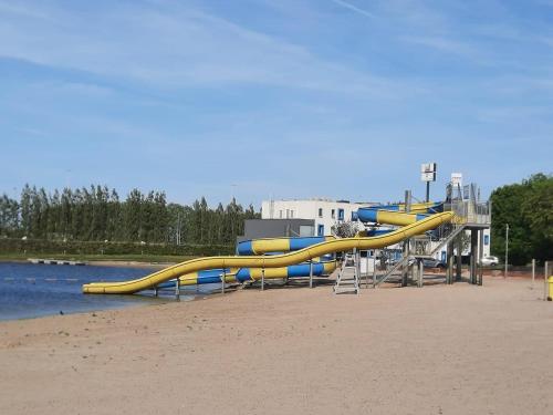 a playground with a yellow slide on the beach at chaletje tis-ier-goed in Jabbeke