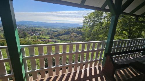 a porch with a bench and a view of the valley at Jurina Hiža in Beletinec