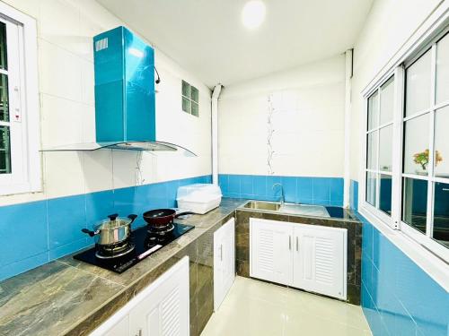 a blue and white kitchen with a stove at Mali house Hatyai in Hat Yai