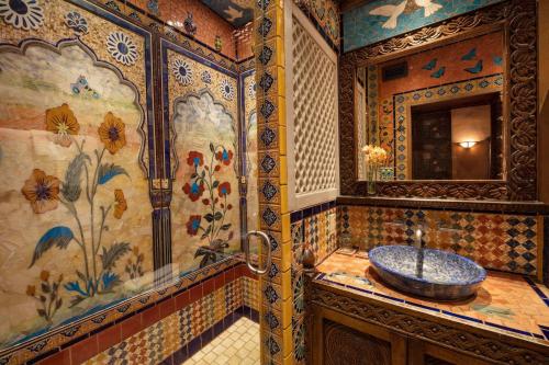 a bathroom with a sink and a mosaic wall at The Inn of Five Graces in Santa Fe