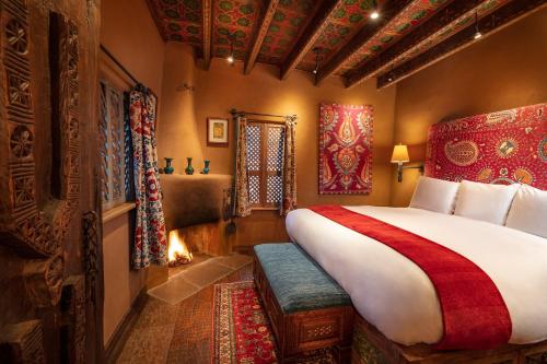 a bedroom with a large bed and a fireplace at The Inn of Five Graces in Santa Fe