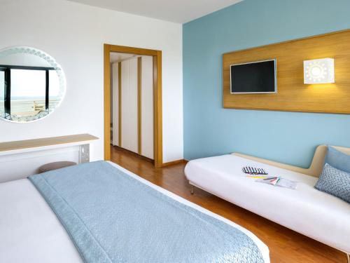 a bedroom with a bed and a tv on the wall at TUI BLUE Manar in Hammamet