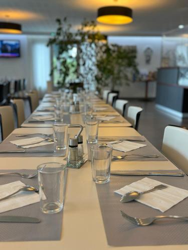 a long table with glasses and napkins on it at Brit Hotel Mayenne in Mayenne