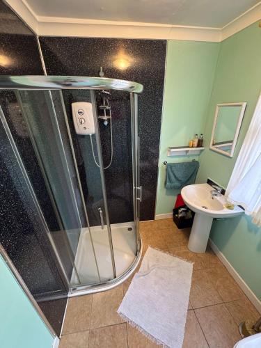 a bathroom with a shower and a sink at Ullapool Lawyur's patch in Ullapool