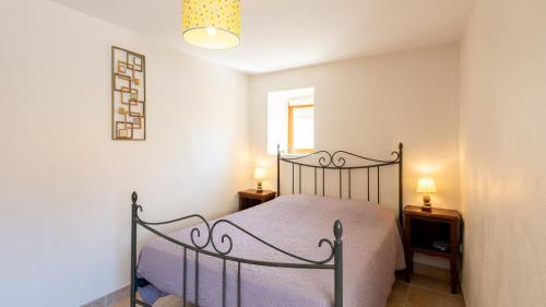 une chambre avec un lit et deux tables de nuit dans l'établissement Gîte Gîte du Bouquet 4/5 personnes, à Saint-Georges-de-Lévéjac