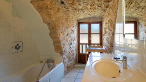 une salle de bain avec un lavabo et une baignoire dans l'établissement Gîte Gîte du Bouquet 4/5 personnes, à Saint-Georges-de-Lévéjac