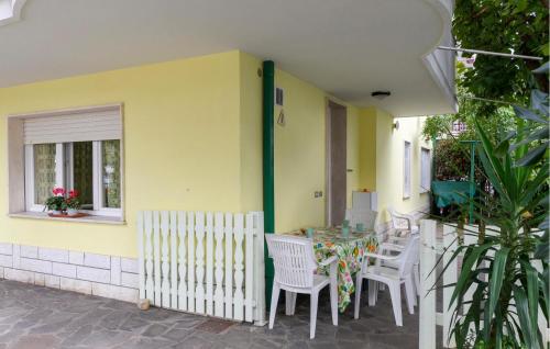 a patio with a table and chairs and a yellow wall at Casa Del Gelsomino in Misano Adriatico