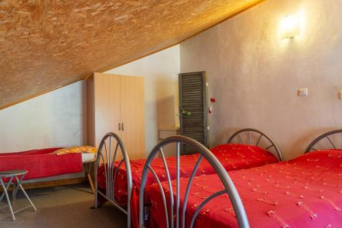 - une chambre avec 2 lits avec des draps rouges et une table dans l'établissement Gite 