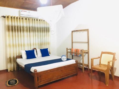 a bedroom with a bed and a chair at Sakula Villa Inn in Weligama
