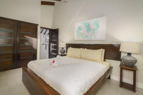 a bedroom with a bed with a stuffed animal on it at Casa de Wilson - 5 Bedroom Beachfront Villa in Maya Beach