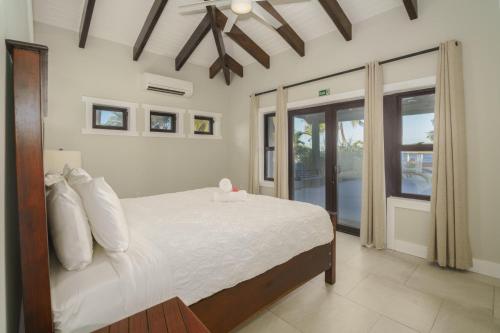 a bedroom with a bed with white sheets and a ceiling at Casa de Wilson - 5 Bedroom Beachfront Villa in Maya Beach