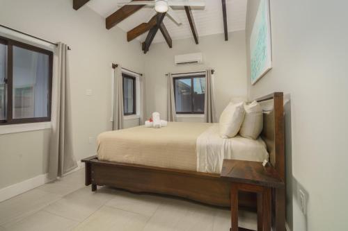 a bedroom with a bed and a ceiling fan at Casa de Wilson - 5 Bedroom Beachfront Villa in Maya Beach