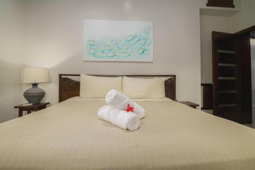 a towel animal is sitting on a bed at Casa de Wilson - 5 Bedroom Beachfront Villa in Maya Beach