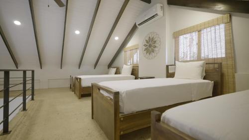 a room with two beds and a window in a room at Casa de Wilson - 5 Bedroom Beachfront Villa in Maya Beach