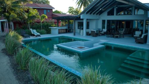 a swimming pool in the backyard of a house at Casa de Wilson - 5 Bedroom Beachfront Villa in Maya Beach