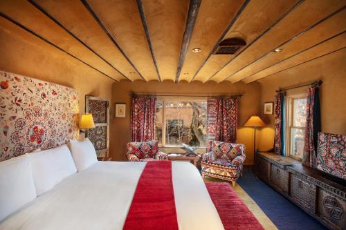 a bedroom with a large bed with a red rug at The Inn of Five Graces in Santa Fe