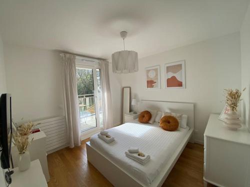 une chambre blanche avec un lit et une fenêtre dans l'établissement Harmonieux Yourhosthelper, à Chaville