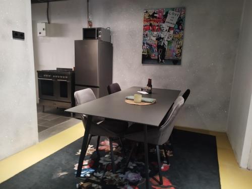 a kitchen with a table with chairs and a refrigerator at Happy in Deventer in Deventer
