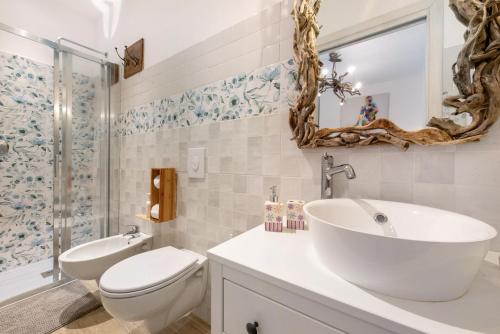 a bathroom with a sink and a toilet and a mirror at Kella's Holiday Home in Bellagio