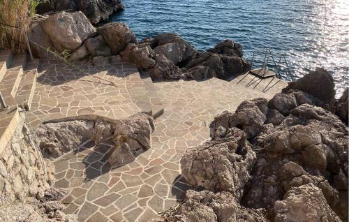 Una playa con algunas rocas y el agua. en Villa Mirvami Lovran, en Opatija