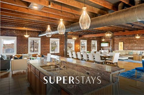 a kitchen with a sink and a living room at KING Penthouse Sleep8 4Bed 3BR 2BA Swepson Loft in Louisville
