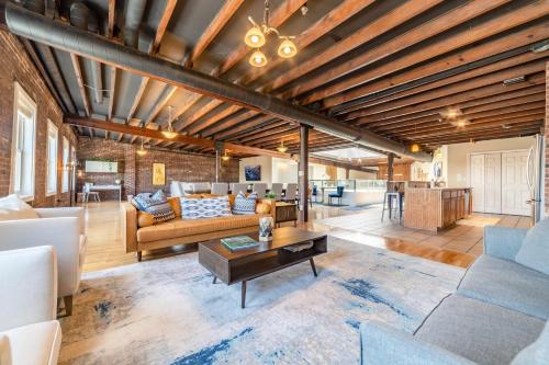 a living room with a couch and a table at KING Penthouse Sleep8 4Bed 3BR 2BA Swepson Loft in Louisville