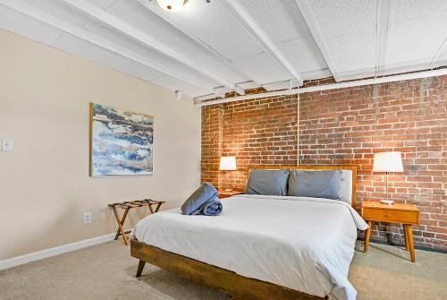 a bedroom with a bed and a brick wall at KING Penthouse Sleep8 4Bed 3BR 2BA Swepson Loft in Louisville