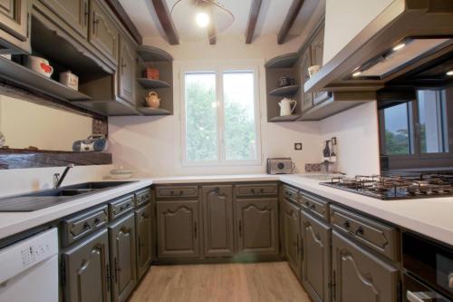 a kitchen with green cabinets and a window at Hego-aldea in Autevielle-Saint-Martin-Bideren