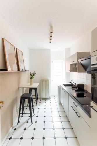 a kitchen with a black and white tiled floor at JAMA - Designapartment im Herzen der Stadt in Schweinfurt
