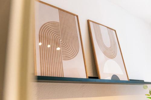 a shelf with two framed pictures on it at JAMA - Designapartment im Herzen der Stadt in Schweinfurt