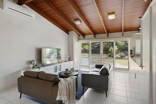 a living room with a couch and a table at Charming 4BR House with Parking near Sunnybank in Brisbane