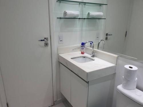 un bagno bianco con lavandino e WC di Flat com Ar, SmarTV43, wifi, estac, novo, Selenita2 a Barueri