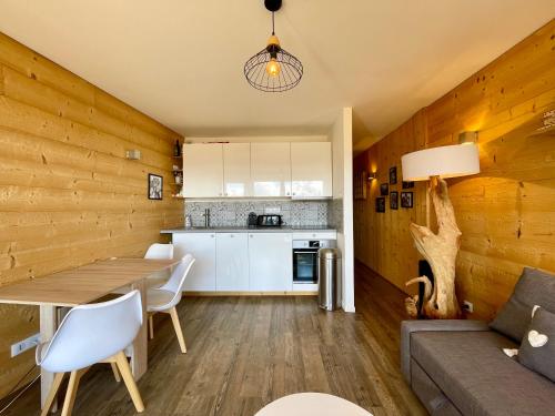 Il comprend une cuisine et un salon avec un mur en bois. dans l'établissement Homency - Résidence Les Gémeaux I3, à L'Alpe-d'Huez