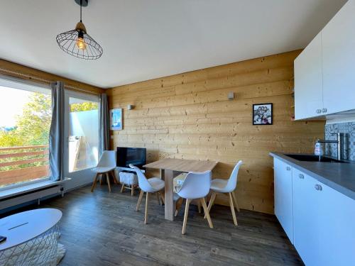 une cuisine et une salle à manger avec une table et des chaises dans l'établissement Homency - Résidence Les Gémeaux I3, à L'Alpe-d'Huez