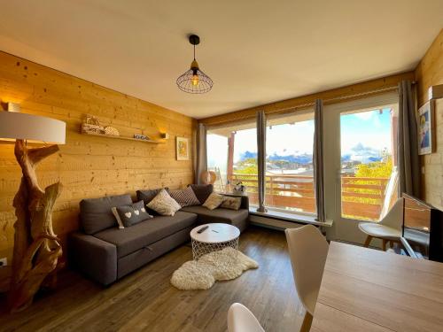 un salon avec un canapé et une table dans l'établissement Homency - Résidence Les Gémeaux I3, à L'Alpe-d'Huez