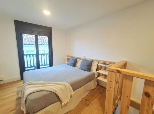 um quarto com uma cama e uma janela em Casa típica Betanzos Casco Histórico em Betanzos