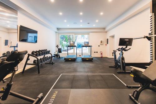a gym with treadmills and machines in a room at J Maluni City Hotel in Rome