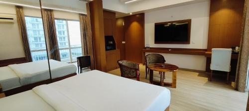 a hotel room with a bedroom with a bed and a desk at Golden Penthouse - Couple Friendly - DLF My Pad, Gomtinagar, Lucknow in Lucknow
