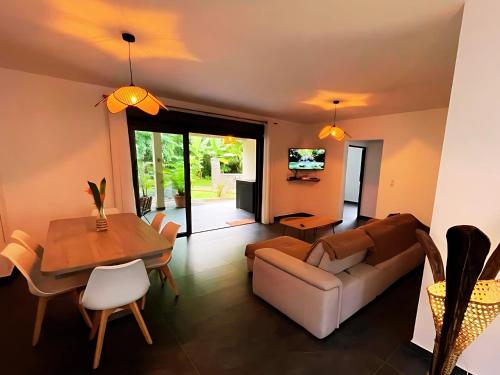 a living room with a couch and a table at Villa Les Jardins de la Trinité in Saint-Philippe