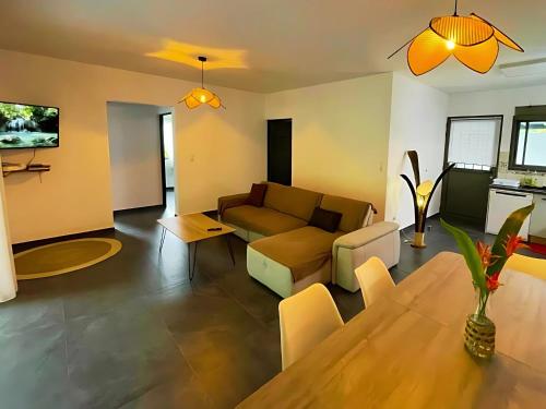 a living room with a couch and a table at Villa Les Jardins de la Trinité in Saint-Philippe