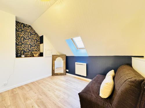 a living room with a couch and a mirror at Le Grand Bricoin - Campagne - Parking - 12 pers in Thorigné-sur-Dué