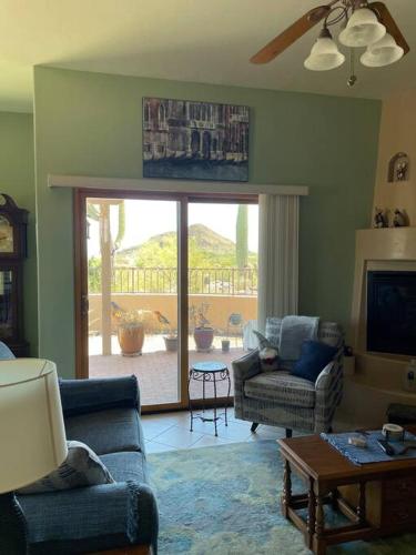 a living room with two chairs and a sliding glass door at Tucson Mnt Foothills Saguaro Bliss in Tucson