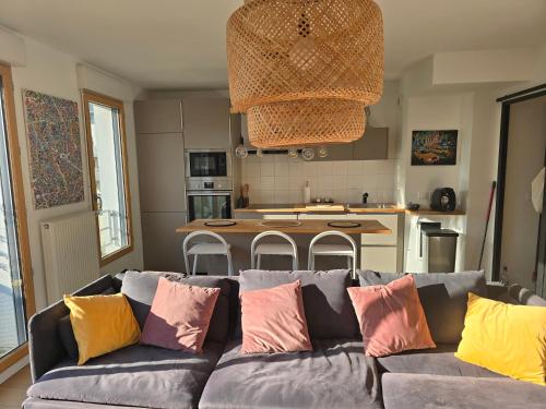- un salon avec un canapé et des oreillers colorés dans l'établissement Parisiano Appartement, à Villejuif