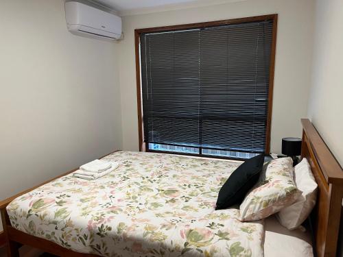 a small bedroom with a bed with a window at Charming 4BR Retreat near Gawler in Gawler